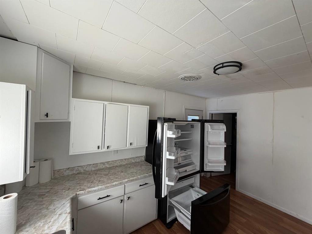 812 Tennessee Street Graham, TX 76450 - Photo 5 of 21 a kitchen with granite countertop a refrigerator and a stove top oven