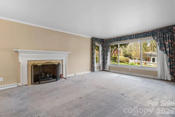a view of an empty room with a fireplace and a window