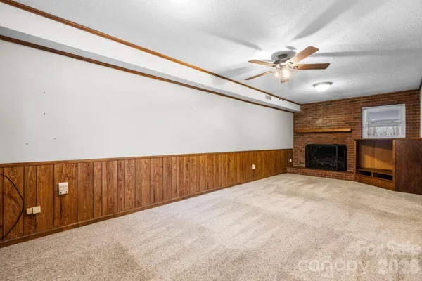a view of an empty room with a fireplace and a window