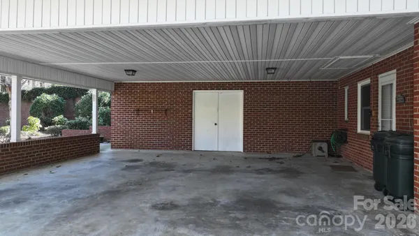 a front view of a house with a garden and trees
