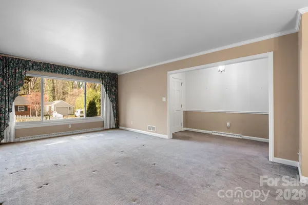 an empty room with large window and from the ceiling window