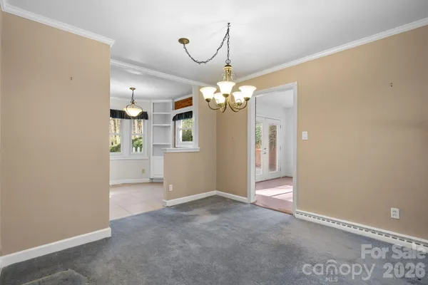 a view of a chandelier in big room and a bathroom
