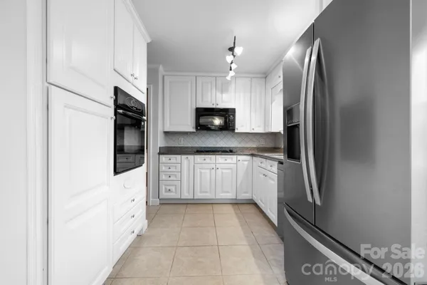 a large white kitchen with cabinets and stainless steel appliances