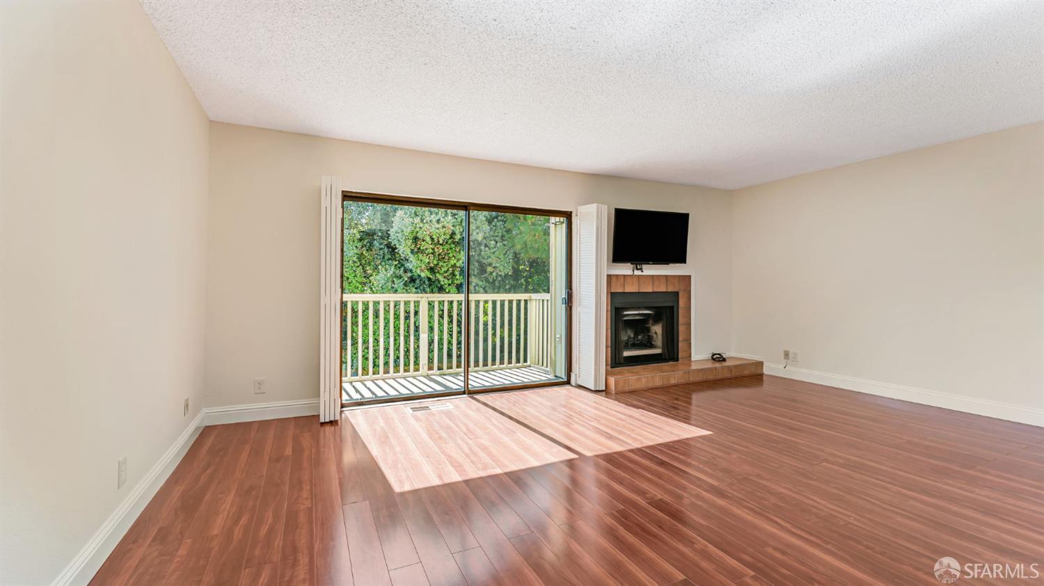 107 Alice Lane El Sobrante, CA 94803 - Photo 13 of 39 a view of a room with wooden floor a fireplace and a window