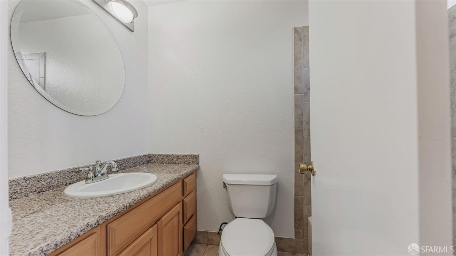 107 Alice Lane El Sobrante, CA 94803 - Photo 31 of 39 a bathroom with a granite countertop sink a toilet and a mirror