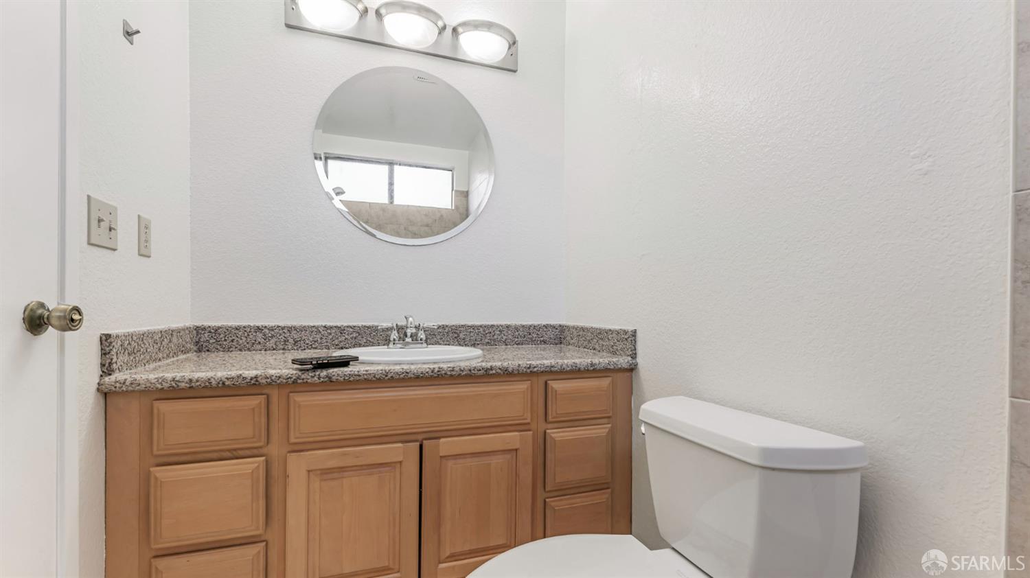 107 Alice Lane El Sobrante, CA 94803 - Photo 33 of 39 a bathroom with a granite countertop toilet sink and mirror