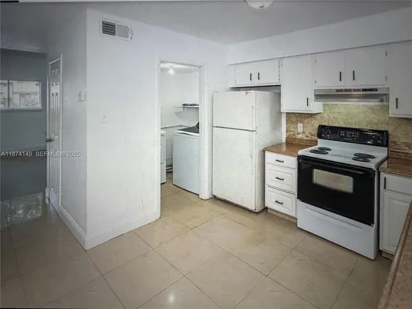 a kitchen with a stove top oven and refrigerator