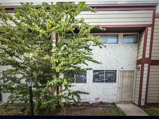 a house that has a tree in front of the house