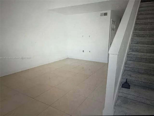 a view of an empty room with stairs