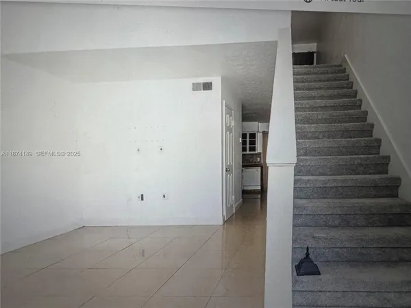 a view of an empty room with stairs and ventilation