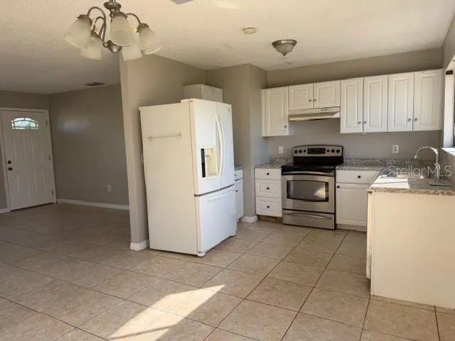 a kitchen with a stove a sink and a refrigerator