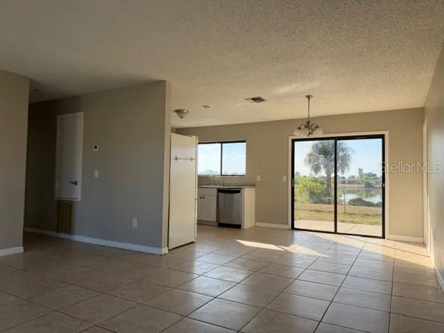 an empty room with sliding door and chandelier