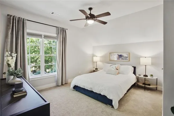 a bedroom with a bed couch and a large window