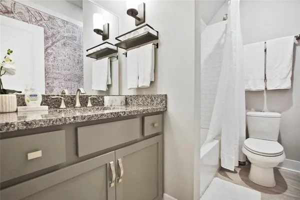 a bathroom with a granite countertop sink a toilet and a mirror