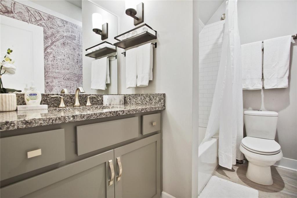 692 Drewry Street Northeast Atlanta, GA 30306 - Photo 17 of 25 a bathroom with a granite countertop sink a toilet and a mirror