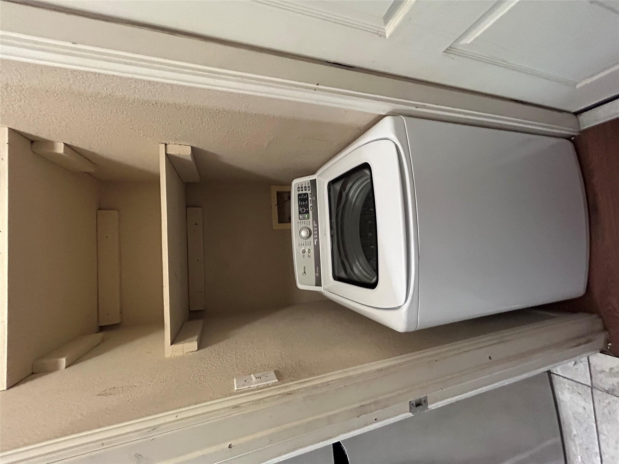 5708 Spring Meadow Road, Unit B Austin, TX 78744 - Photo 10 of 23 Laundry area featuring washer / dryer and a textured wall