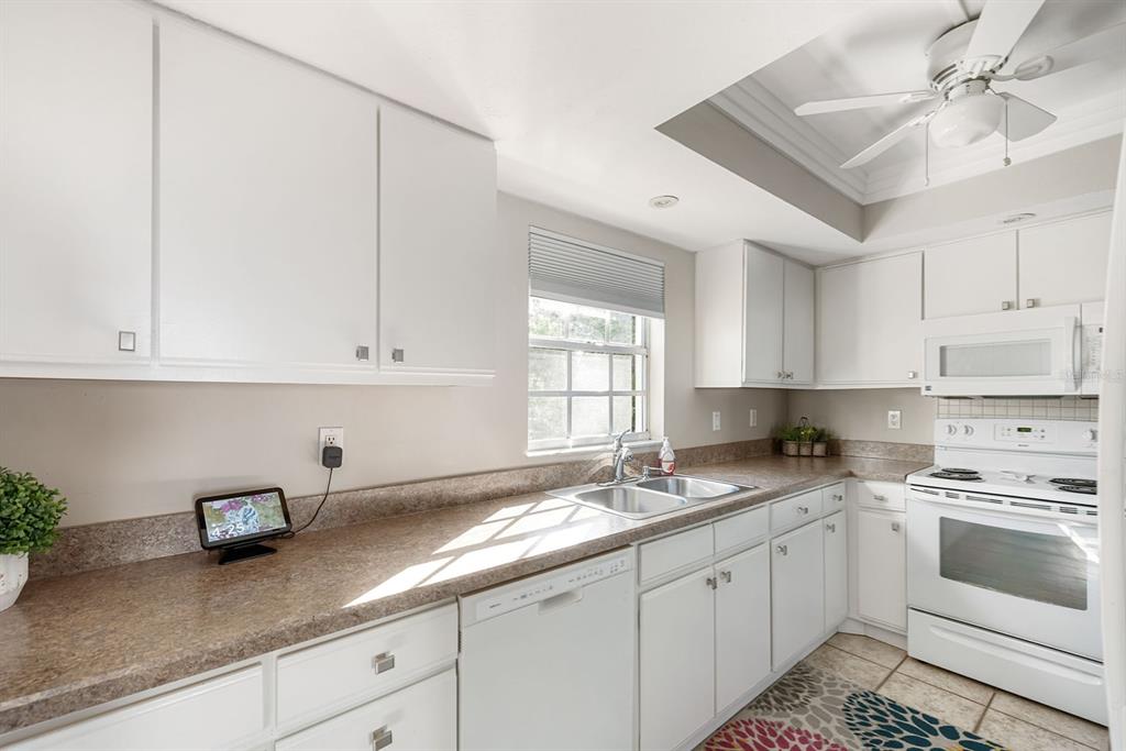 1531 Placida Road, Unit 8101 Englewood, FL 34223 - Photo 31 of 76 a kitchen with granite countertop white cabinets white appliances and sink