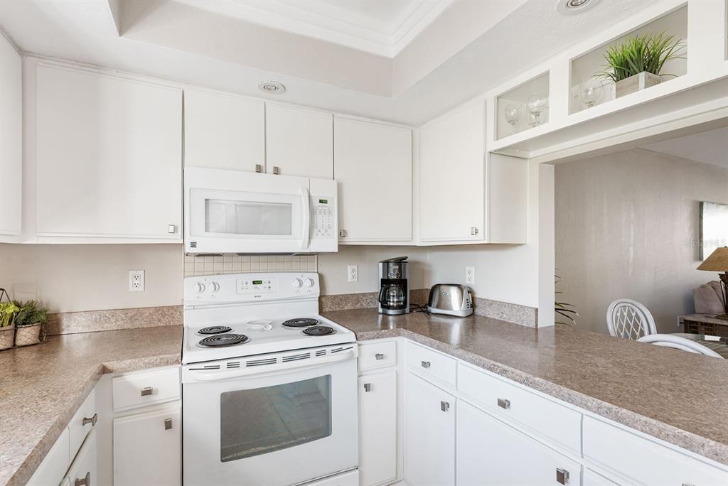 1531 Placida Road, Unit 8101 Englewood, FL 34223 - Photo 34 of 76 a kitchen with granite countertop white cabinets white stainless steel appliances and sink