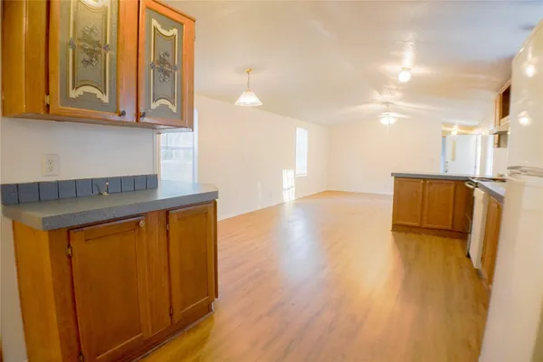 a view of kitchen with stainless steel appliances granite countertop cabinets and wooden floor