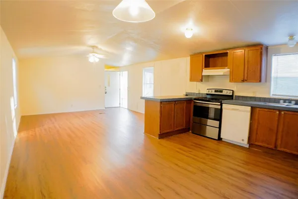 a kitchen with granite countertop a sink cabinets and stainless steel appliances