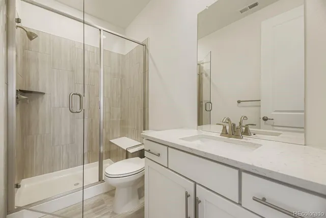 a bathroom with a granite countertop sink toilet and shower