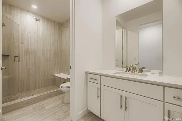 a bathroom with a double vanity sink toilet and shower