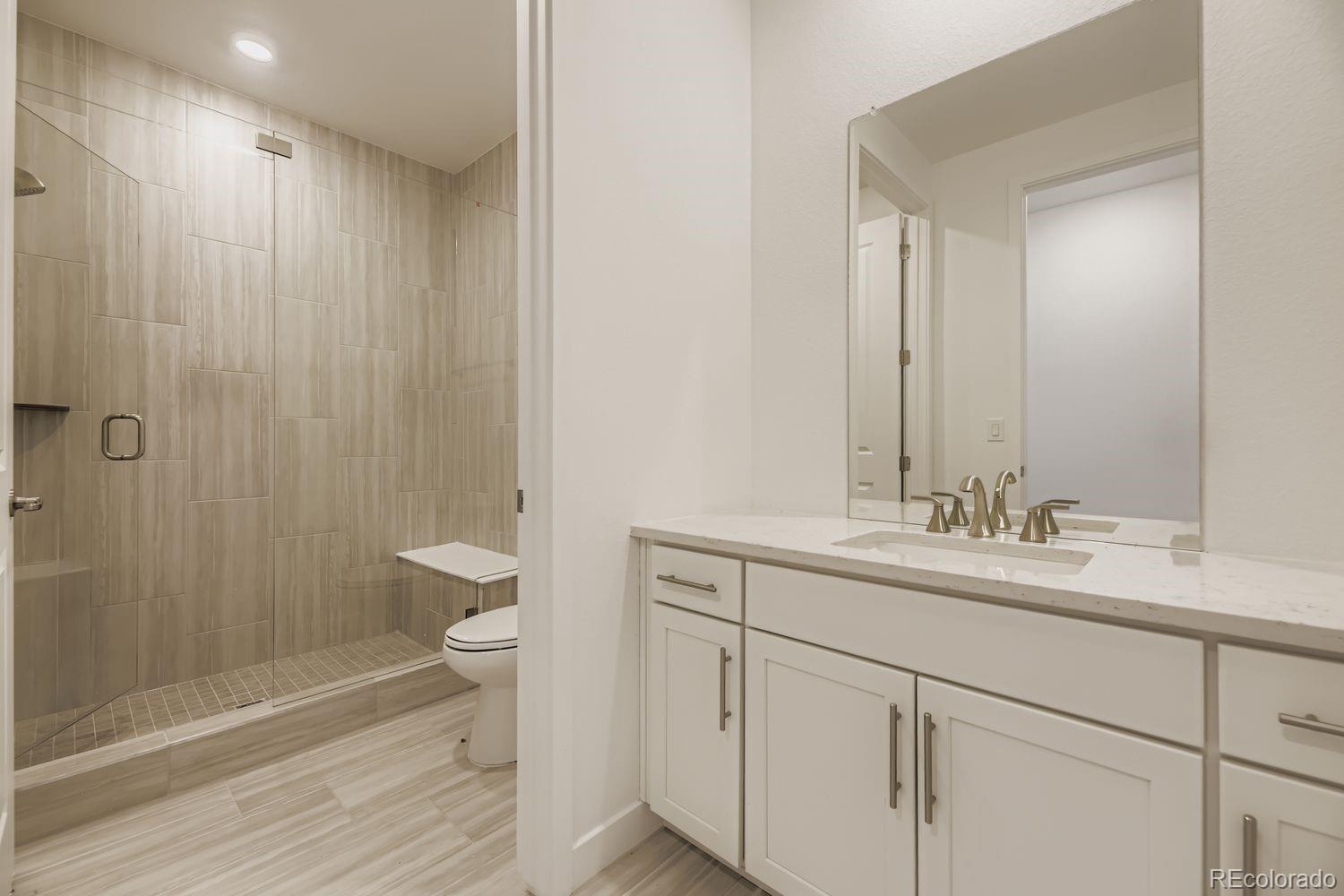 15596 West Beloit Avenue Morrison, CO 80465 - Photo 4 of 23 a bathroom with a double vanity sink toilet and shower