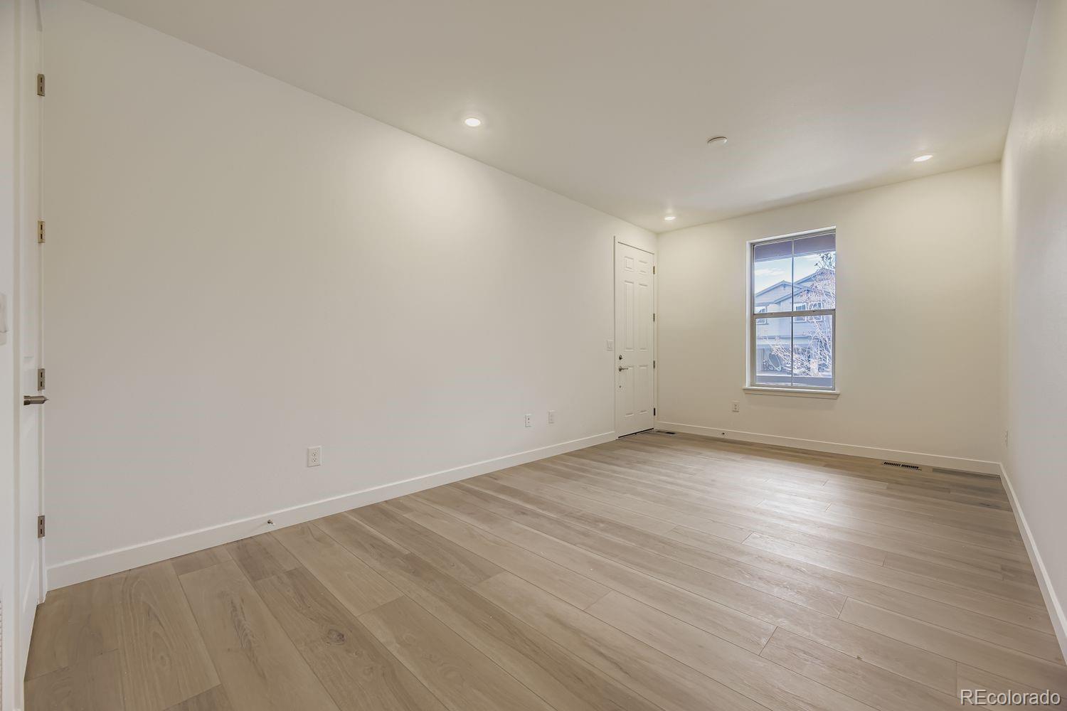 15596 West Beloit Avenue Morrison, CO 80465 - Photo 5 of 23 an empty room with wooden floor and windows