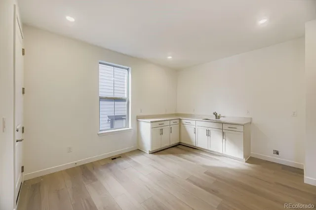 a view of a kitchen with wooden floor and electronic appliances