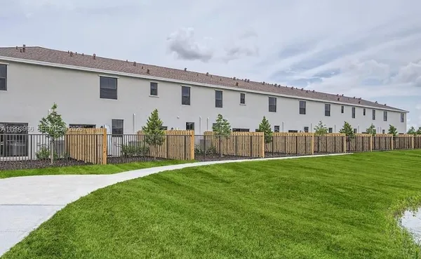 a view of a backyard with plants and wooden fence