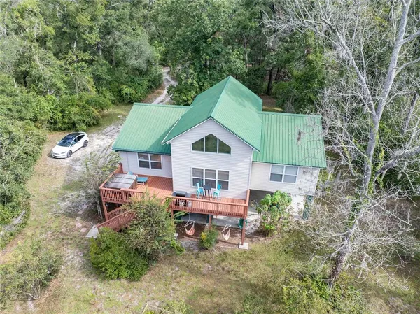 an aerial view of a house with a yard and sitting area