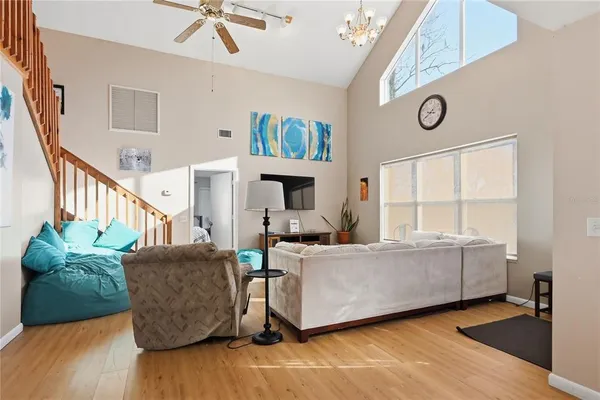 a living room with furniture a flat screen tv and a window