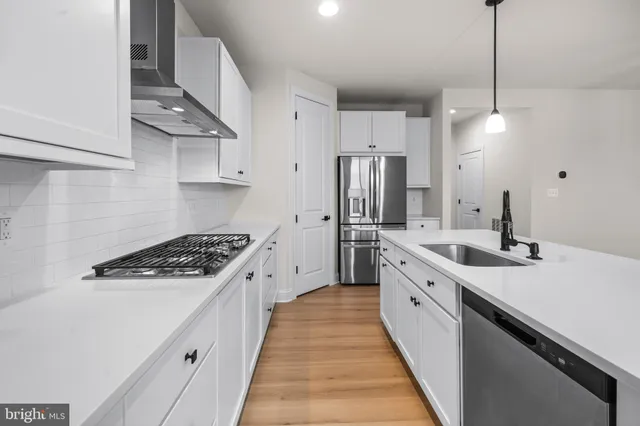 a kitchen with stainless steel appliances a sink stove and refrigerator
