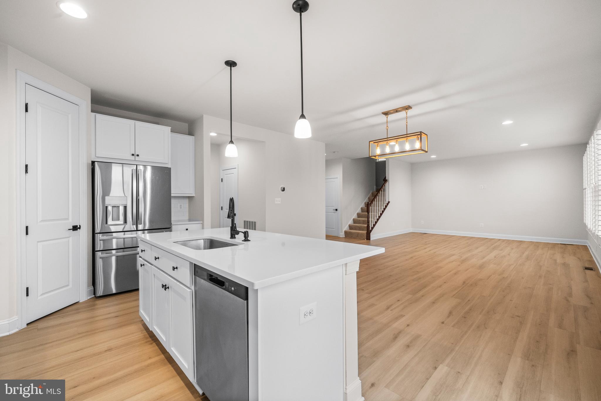 9516 Kimbleton Hall Loop Manassas Park, VA 20111 - Photo 16 of 51 a room with kitchen island a sink and wooden floor