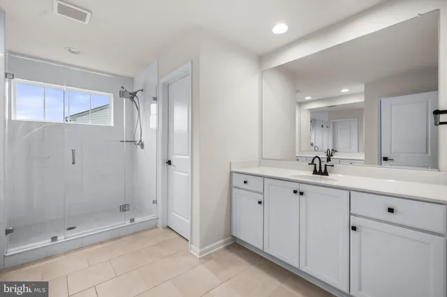 a bathroom with a shower sink and mirror