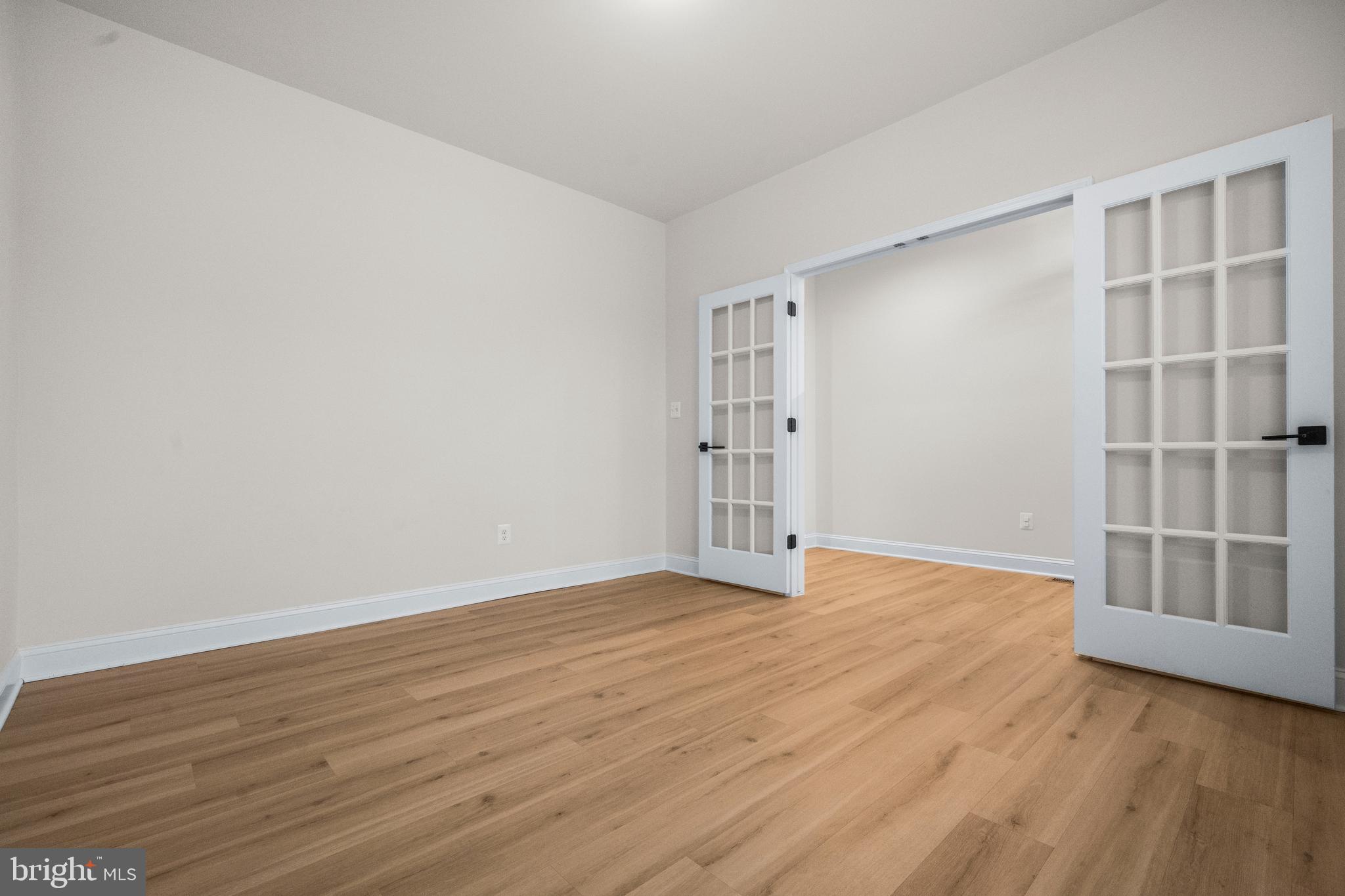 9516 Kimbleton Hall Loop Manassas Park, VA 20111 - Photo 6 of 51 a view of an empty room with wooden floor and a window