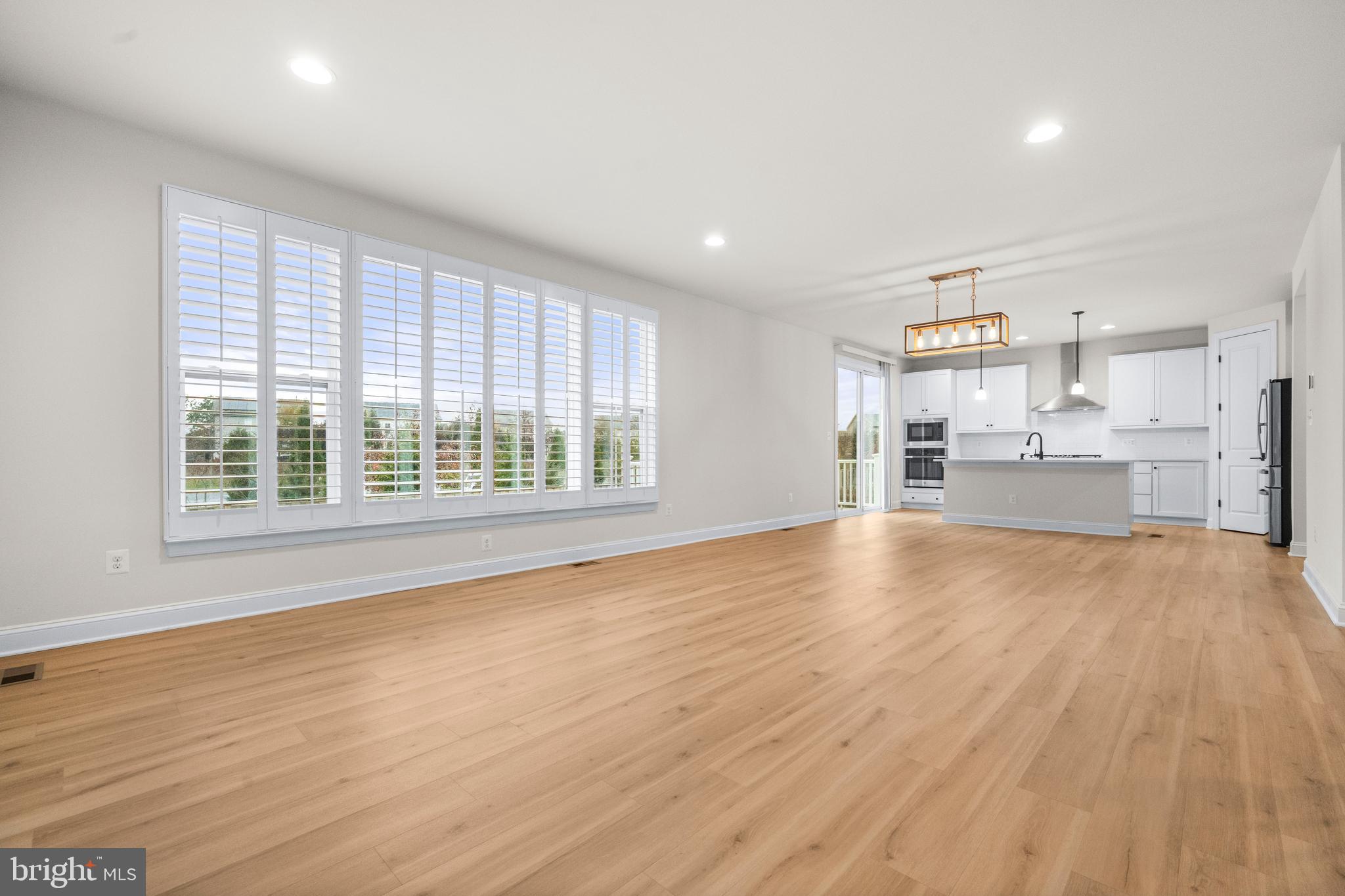 9516 Kimbleton Hall Loop Manassas Park, VA 20111 - Photo 10 of 51 a view of empty room with wooden floor and kitchen view