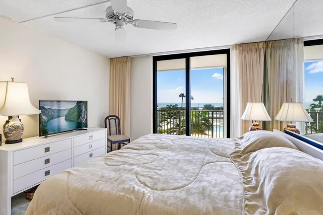 a bedroom with a large bed and a flat tv screen on dresser