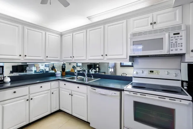 a kitchen with granite countertop white cabinets and a stove