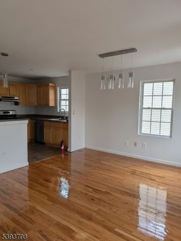 a view of a kitchen with wooden floor and a window