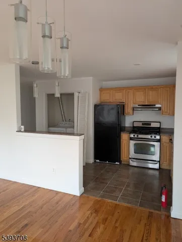 a kitchen with granite countertop a refrigerator and a stove top oven