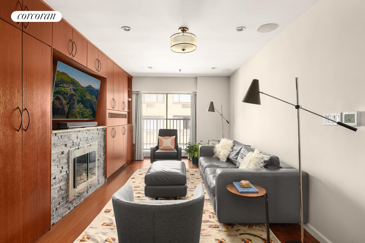 67 East 11th Street, Unit 705 Manhattan, NY 10003 - Photo 3 of 10 a living room with furniture and a fireplace