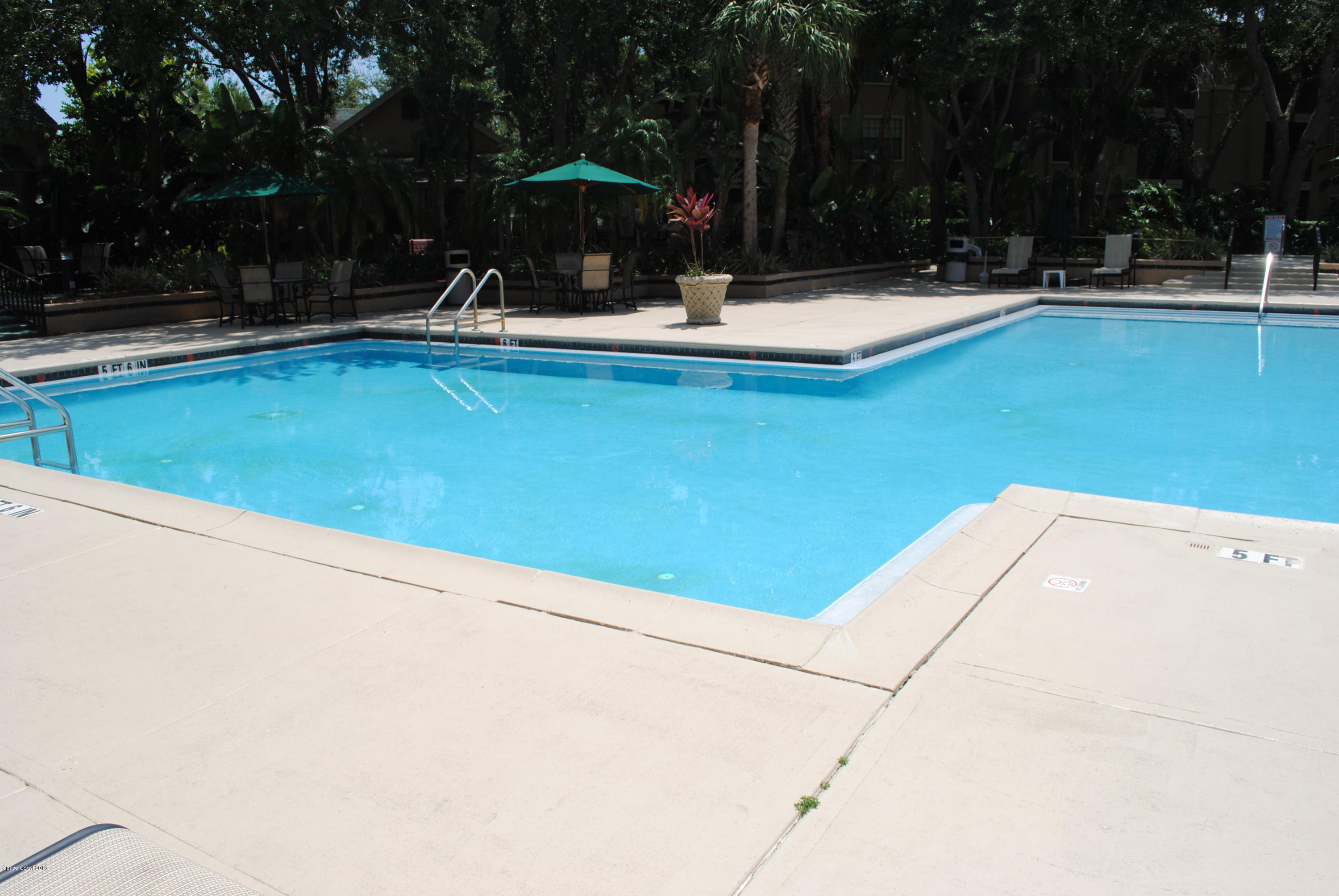 7667 North Wickham Road, Unit 812 Melbourne, FL 32940 - Photo 13 of 17 a view of swimming pool with table and chairs under an umbrella