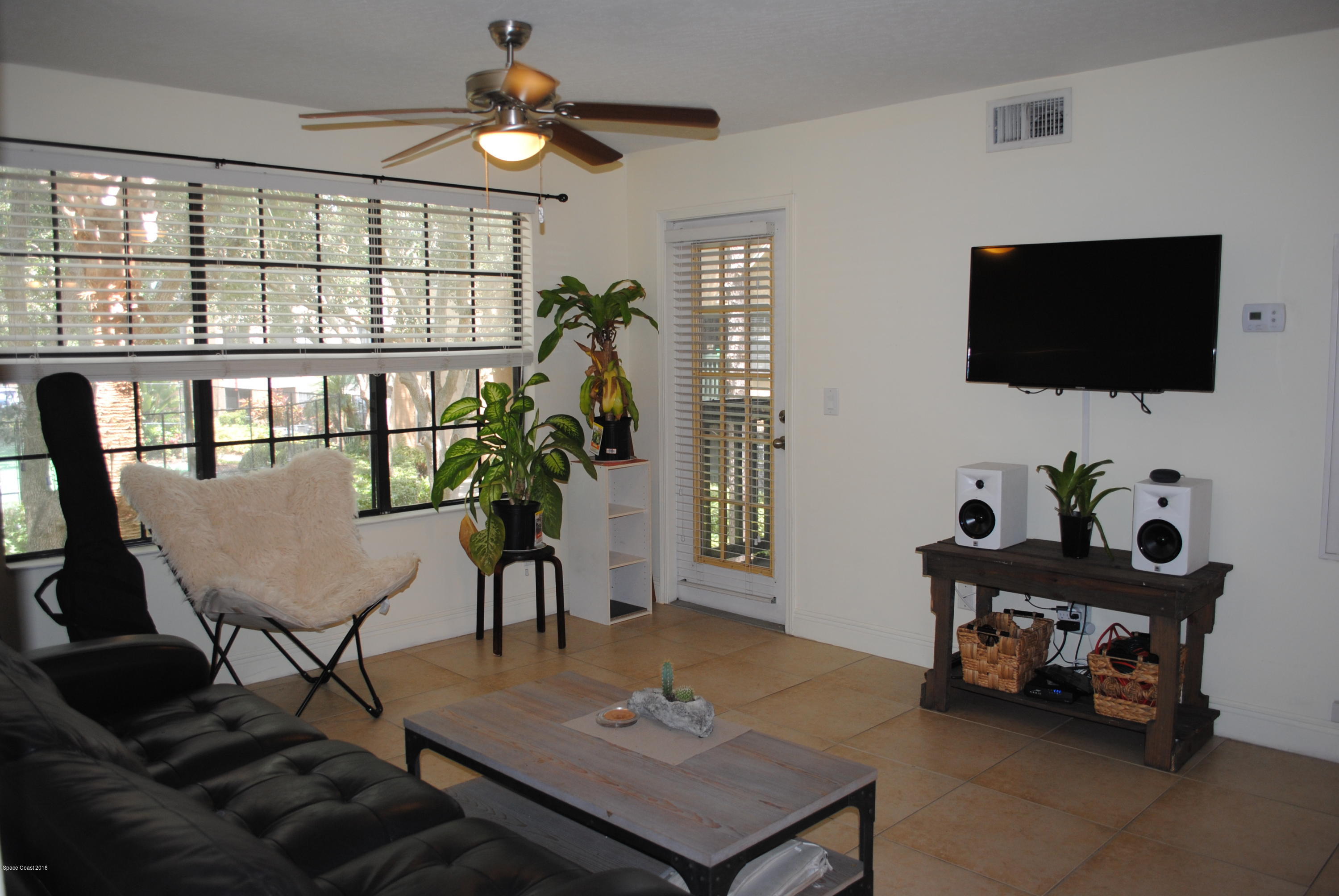 7667 North Wickham Road, Unit 812 Melbourne, FL 32940 - Photo 4 of 17 a living room with furniture and a flat screen tv