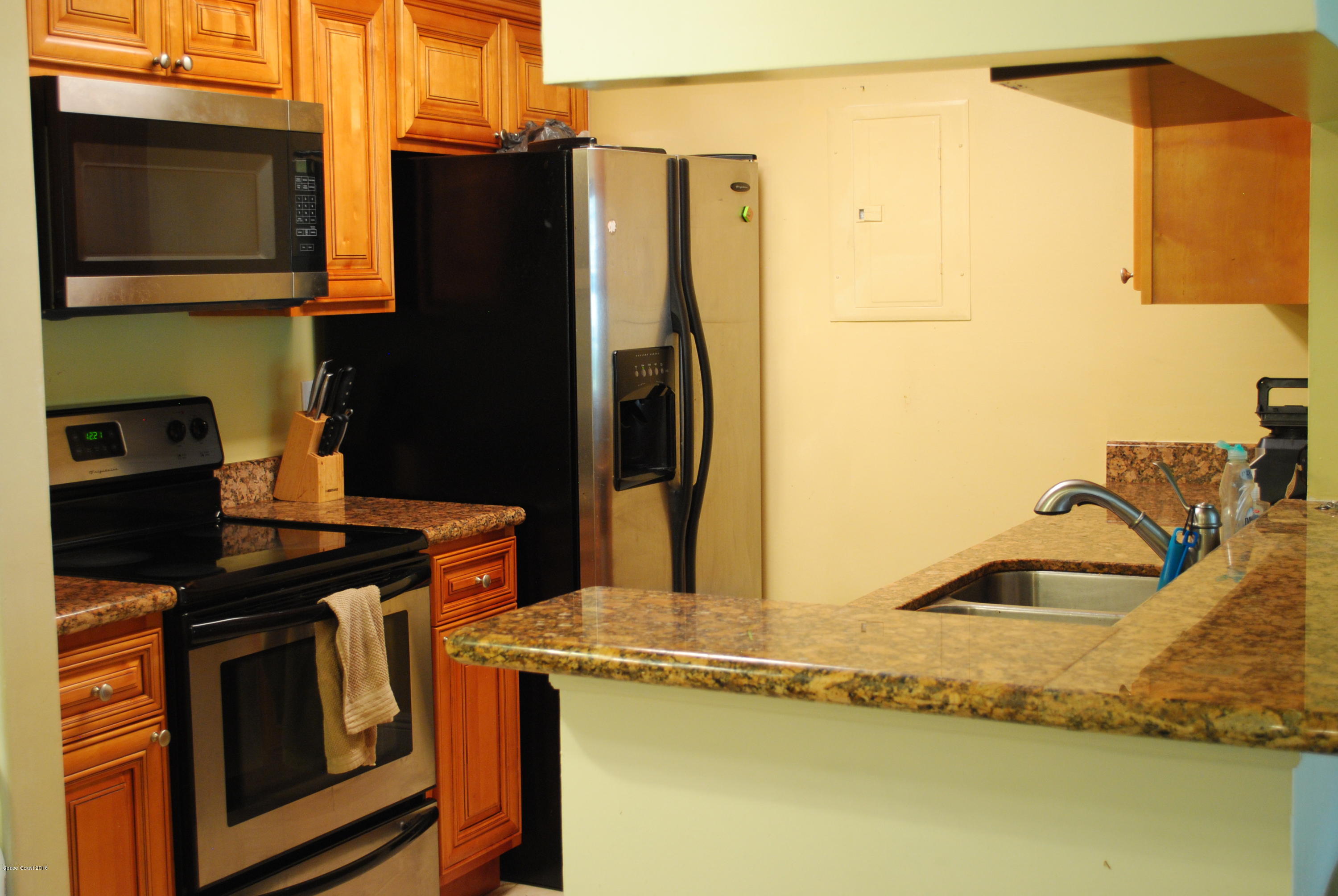 7667 North Wickham Road, Unit 812 Melbourne, FL 32940 - Photo 6 of 17 a kitchen with stainless steel appliances granite countertop a refrigerator and a stove