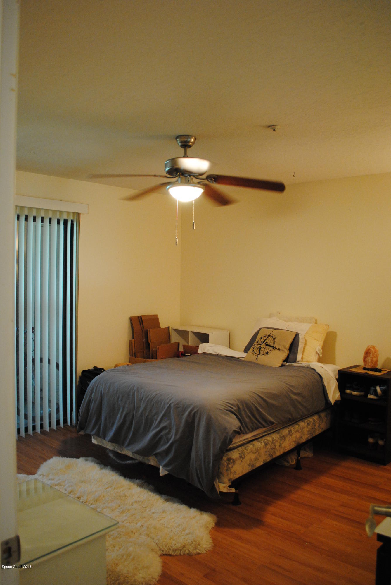 7667 North Wickham Road, Unit 812 Melbourne, FL 32940 - Photo 9 of 17 a bedroom with a bed and wooden floor