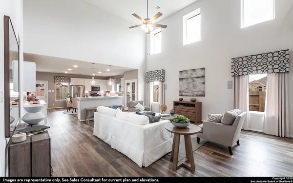 a living room with furniture a fireplace and a chandelier