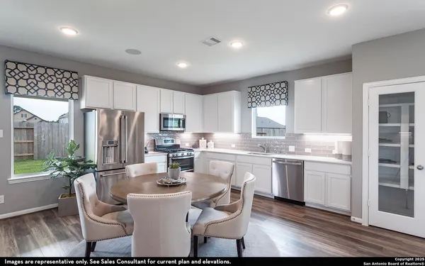 a kitchen with refrigerator and chairs