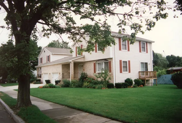 a front view of a house with a garden and yard