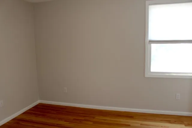 a view of a small space with wooden floor and a window